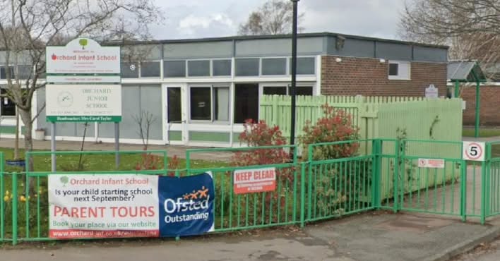Orchard Infant School entrance with green fencing and signage.