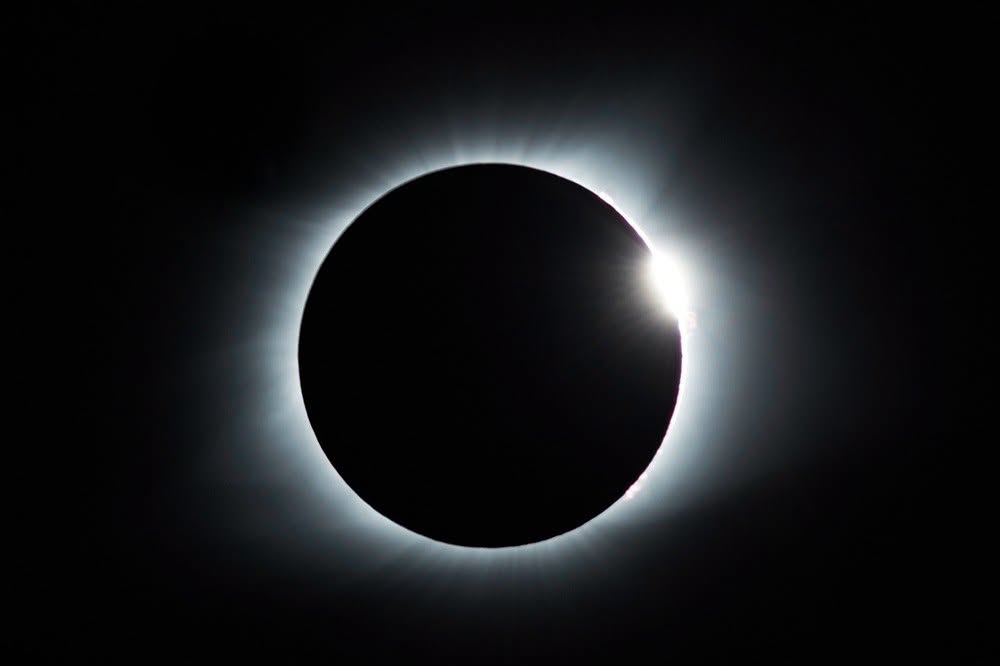 Partial solar eclipse: Moon partially blocks the sun, creating a bright corona