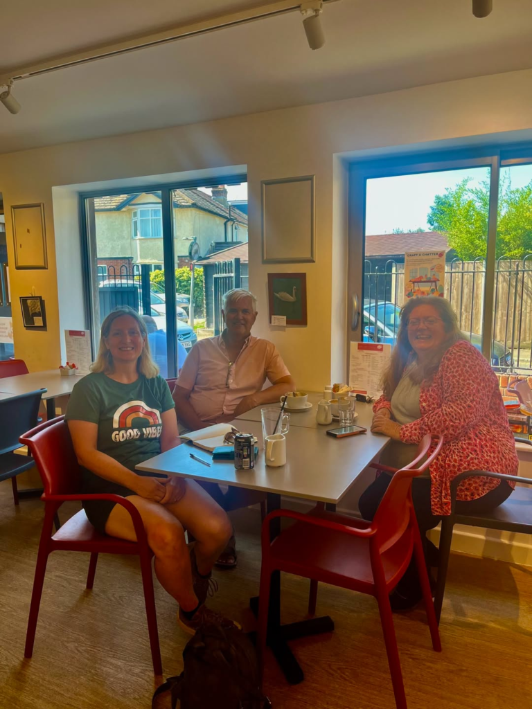 Three people enjoying coffee at a table in Totton cafe