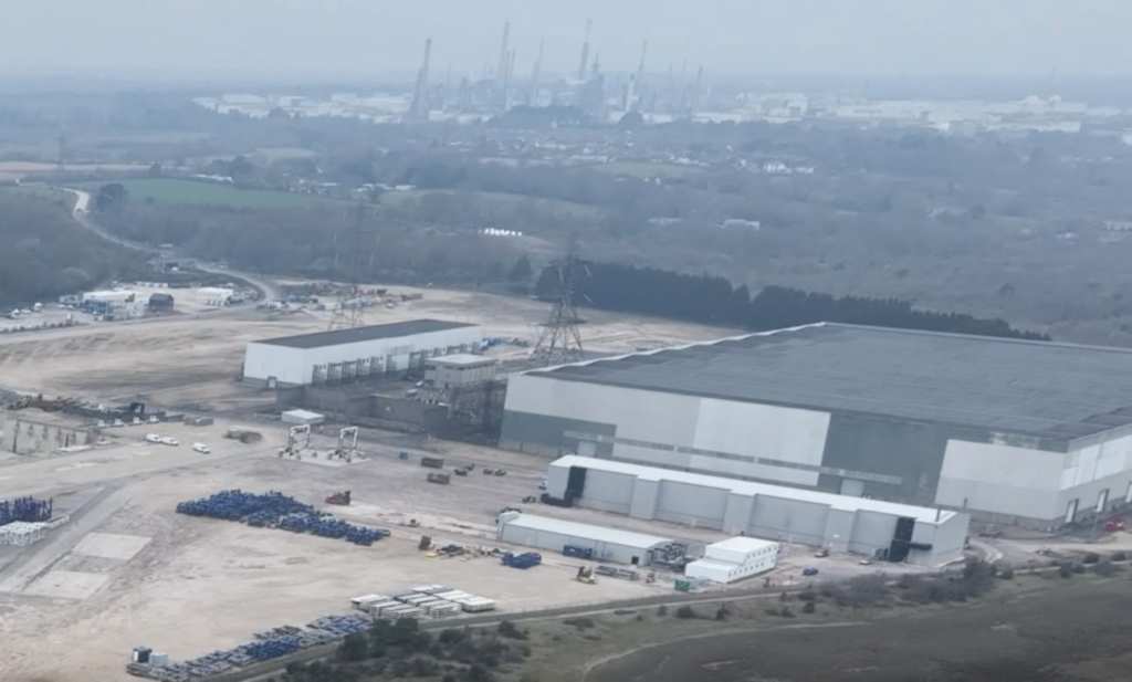 Aerial view of a large data center construction site with industrial background.