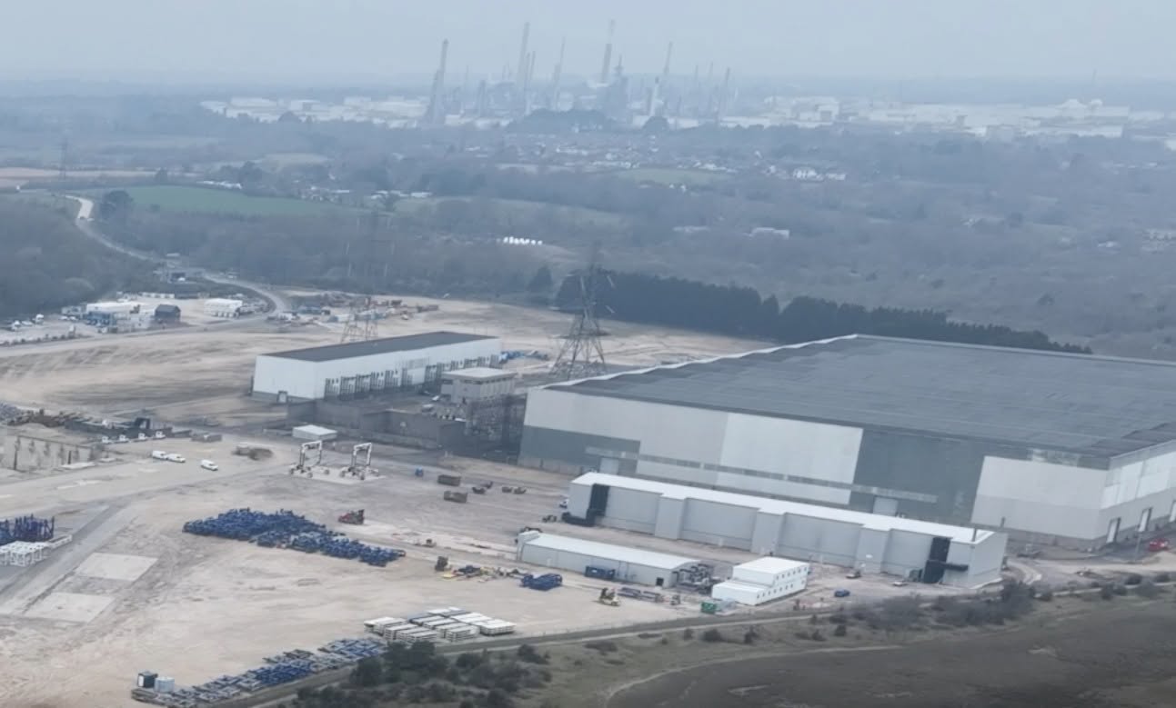 Aerial view of a large data center construction site with industrial background.